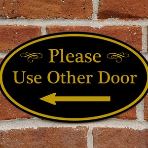 Please Use Other Door Sign With Left Arrow - Aluminum Oval 12&quot; x 7&quot; Plaque - Variety of Colors Available