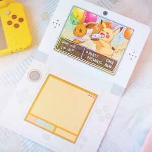 Puede incluir: Una consola de juegos port&aacute;til blanca que muestra en su pantalla a Eevee y Pikachu en una fiesta de cumplea&ntilde;os con el texto What will you do? Party, Presents, Cake, Run. Una consola amarilla es parcialmente visible a la izquierda y una rosa a la derecha.