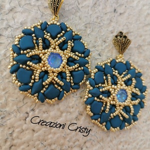 Op de afbeelding: Een paar tealblauwe en gouden kralen oorbellen met een stervormig ontwerp en iriserende blauwe edelstenen. De oorbellen zijn handgemaakt en hebben een uniek, ingewikkeld ontwerp.