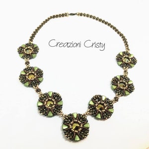 Op de afbeelding: Een groene en bruine kralenketting met een bloemmotief. De ketting heeft zes ronde bloemmotieven met een centrale kristalkralen. De ketting ligt op een witte achtergrond. De tekst "Creazioni Christy" is zichtbaar in de afbeelding.