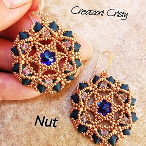 Puede incluir: Un par de pendientes redondos de cuentas doradas y negras con un cristal azul en el centro. Los pendientes tienen un diseño geométrico. El texto "Creazioni Cristy" y "Nut" es visible en la imagen.
