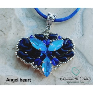 Op de afbeelding: Een zilveren hartvormige ketting met blauwe en zilveren kralen, met een blauw kristalontwerp. De hanger is bevestigd aan een blauw koord.