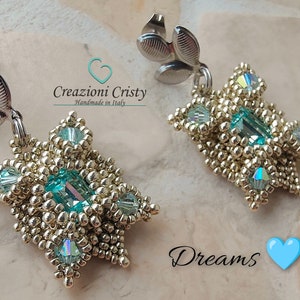 May include: A pair of gold and turquoise beaded earrings with a leaf-shaped dangle. The earrings are handmade in Italy and are called "Dreams".