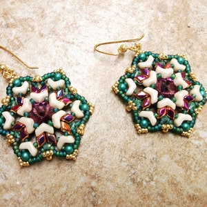 May include: A pair of gold earrings with a green, white, and iridescent purple starburst design.