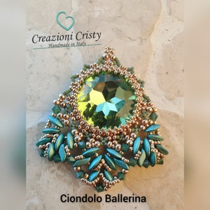 Może przedstawiać: Zielony i złoty wisiorek z dużymi zielonymi kryształami w środku. Wisiorek ma kształt łzy i delikatny, skomplikowany wzór. Na dole zdjęcia widoczny jest napis "Ciondolo Ballerina".