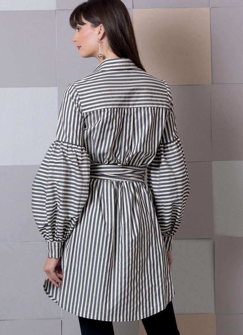May include: A long-sleeved, striped shirt with a tie belt. The shirt has a relaxed fit and features a button-up collar and long, puffy sleeves.