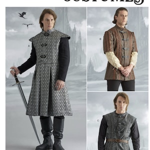 May include: Simplicity S9593 sewing pattern for costumes featuring three variations of tunics. View A is a long, silver patterned tunic with a high collar. View B is a brown tunic with buckles and short sleeves. View C is a dark grey tunic with a belt.