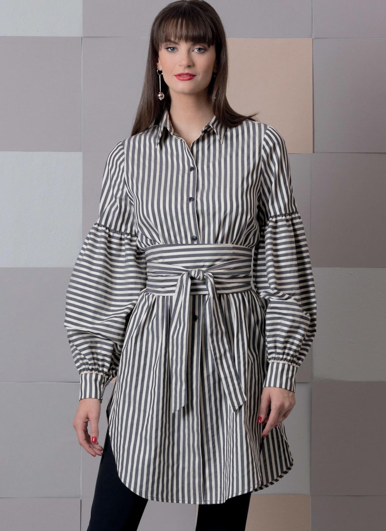 May include: A long-sleeved, striped shirt dress with a black and white pattern. The dress has a tie belt at the waist and a button-up front.