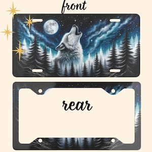 May include: License plate with a howling wolf design. The plate features a wolf howling at the moon, set against a backdrop of a starry night sky and a forest of pine trees. The text "front" is written at the top. The matching frame is included.