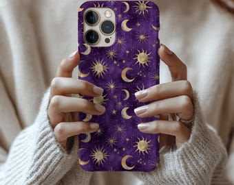 May include: A purple iPhone case with a celestial pattern of gold suns, moons, and stars. The case is held by a person wearing a cream-coloured jumper. The text "Many iPhone size options" is at the top.