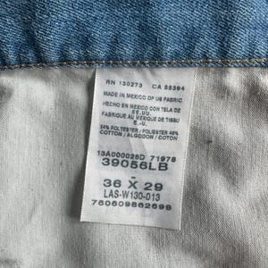 May include: Close-up of light blue denim fabric with a white tag. The tag shows text including "36 X 29" and "39056LB". The tag also indicates the item was made in Mexico.
