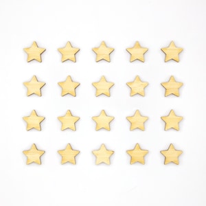 May include: Twenty wooden stars arranged in a grid pattern on a white background. The stars are light brown in colour and have a slightly rough texture.