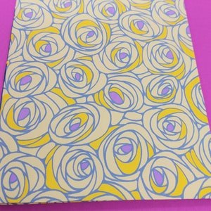 May include: A notebook cover with a repeating pattern of yellow and blue stylized roses with purple centres.