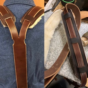 May include: A Y-back leather suspender set featuring smooth brown leather straps with cream-colored shearling lining on the shoulder pads. The design includes stitched edges and a sturdy construction, with a secondary view showing a textured dark brown leather strap.