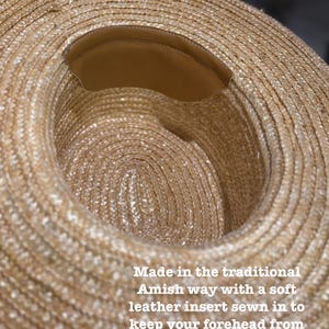 May include: A straw hat with a wide brim and a brown leather insert sewn into the inside. The hat is made in the traditional Amish way. The text on the image says: Made in the traditional Amish way with a soft leather insert sewn in to keep your forehead from being scratched by the straw.