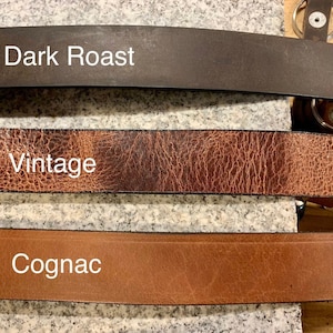 Pu&ograve; includere: Tre cinturini in pelle in diverse tonalit&agrave; di marrone. Il cinturino superiore &egrave; marrone scuro ed &egrave; etichettato "Dark Roast". Il cinturino intermedio &egrave; marrone medio con una superficie testurizzata ed &egrave; etichettato "Vintage". Il cinturino inferiore &egrave; marrone chiaro ed &egrave; etichettato "Cognac".