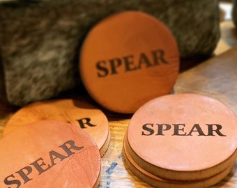 May include: Four brown leather coasters with the word "SPEAR" printed in black lettering.