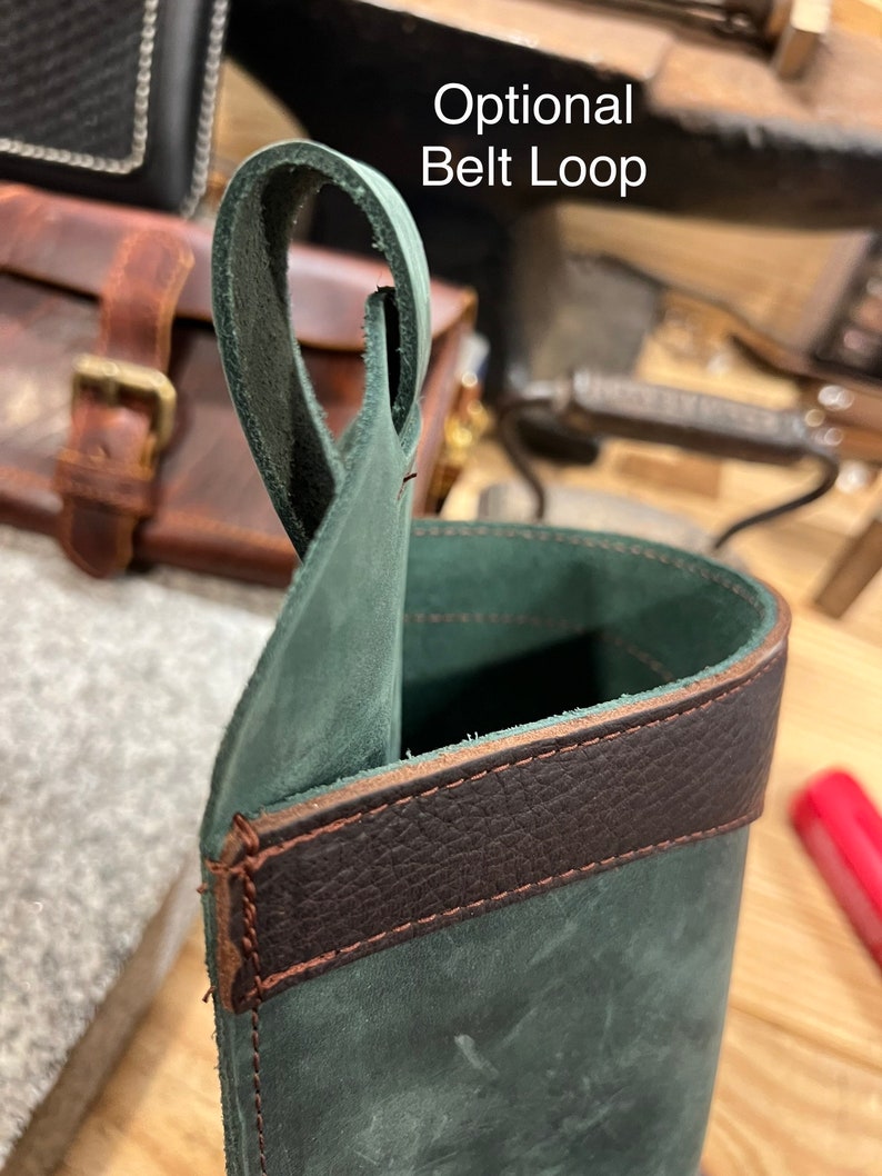 May include: A dark green leather pouch with a brown leather trim. The pouch has an optional belt loop.