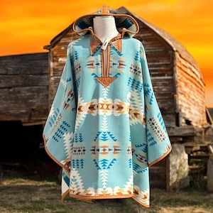 Può includere: Un poncho blu e marrone con cappuccio e bordatura in pelle. Il poncho è realizzato in un tessuto morbido e caldo e ha una vestibilità rilassata.