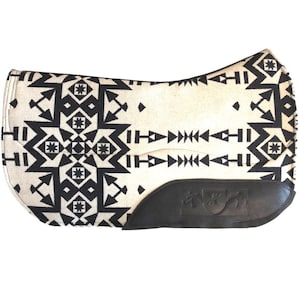 Peut inclure: Un tapis de selle crème avec un motif géométrique noir. Le tapis a un fond en cuir noir et un logo. Le design présente des flèches, des diamants et des formes en étoile, créant une esthétique du Sud-Ouest.