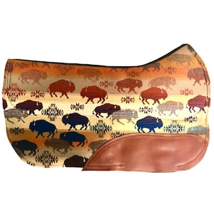 Peut inclure: Un tapis de selle marron et beige avec un motif répété de silhouettes de buffles bleus et bruns. Le tapis de selle a un rabat en cuir brun dans le coin inférieur droit.