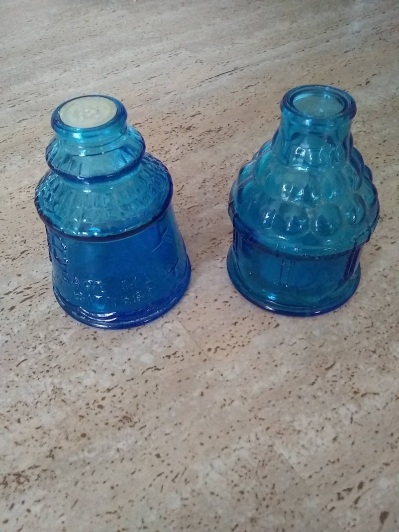 Peut inclure: Deux bouteilles en verre bleu avec une surface textur&eacute;e. Les bouteilles sont vides et ont un aspect vintage.