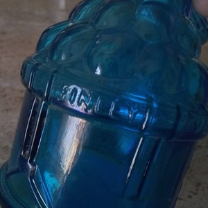 Peut inclure: Une bouteille en verre bleu avec un motif textur&eacute; et le mot "FINELY" en relief sur le c&ocirc;t&eacute;.