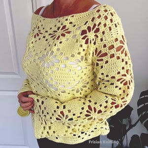 Puede incluir: Un top de crochet amarillo con un patr&oacute;n cuadrado y un dise&ntilde;o calado. El top tiene un escote amplio y mangas largas.