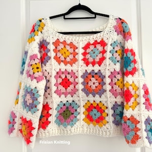 May include: A white crochet sweater with a colourful granny square pattern. The sweater has a loose fit and long sleeves. The text "Frisian Knitting" is visible at the bottom of the image.