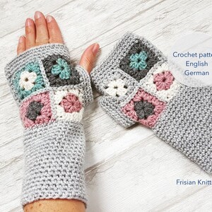 Op de afbeelding: Een paar grijze gehaakte vingerloze handschoenen met een kleurrijk granny square patroon. De handschoenen zijn gemaakt met een textuur-steek en hebben een eenvoudig, elegant ontwerp. Haakpatroon in het Engels en Duits.