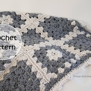Op de afbeelding: Een gehaakt deken met een wit en grijs granny square patroon. Het deken heeft een gehaakte rand. De tekst "Crochet pattern" is zichtbaar in de afbeelding.