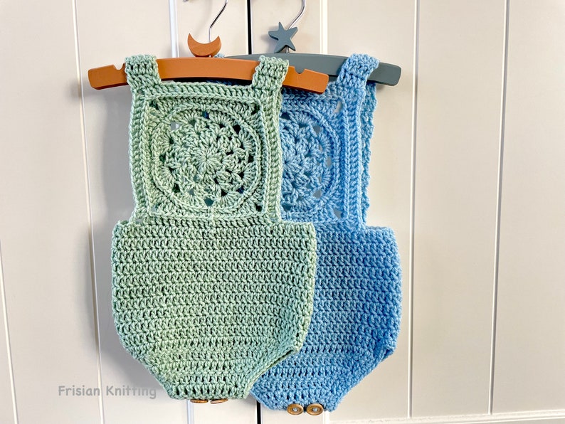 May include: Two crocheted baby onesies, one in a light green color and one in a light blue color. Both onesies have a crocheted square design on the front with a circular pattern in the center.
