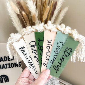 Puede incluir: Conjunto de seis marcap&aacute;ginas verdes, beige y blancos con letras de caligraf&iacute;a negra. Las palabras en los marcap&aacute;ginas son "Strong", "Everything", "Morning", "Chosen", "Love" y "Beautiful".