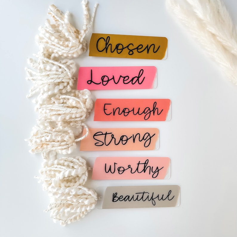Puede incluir: Seis marcadores de colores con palabras inspiradoras: Elegido, Amado, Suficiente, Fuerte, Digno y Hermoso. Cada marcador tiene un borla blanca.