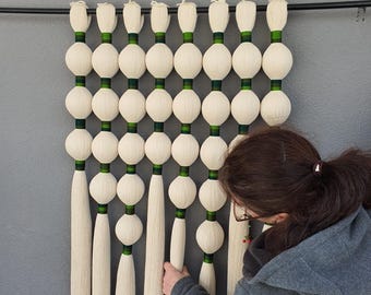 Arte mural de fibra: bolas de macramé para habitación infantil estilo bohemio