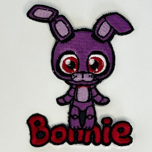 May include: Purple and red embroidered patch of a cartoon bunny with the word "Bonnie" underneath.