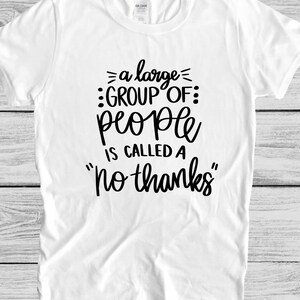 May include: White t-shirt with black text that reads "a large group of people is called a "no thanks""