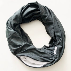 May include: A dark grey infinity scarf with a zipper opening and a white label that says "Mommy's Daughter".