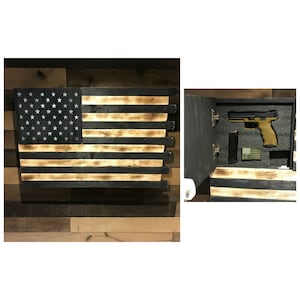 May include: A wooden American flag with a hidden compartment that opens to reveal a handgun and magazine. The flag is painted black and brown with a distressed look.