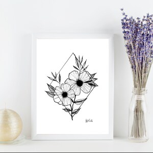 May include: A framed black and white floral art print featuring two flowers within a diamond shape, with leaves and stems. A vase of lavender and a gold candle are also in the image, creating a minimalist aesthetic.