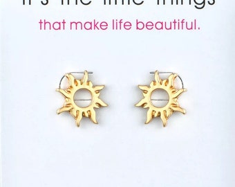 May include: Gold sun earrings with a simple design. The earrings are on a white background with the text "it's the little things that make life beautiful."