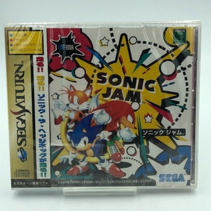 May include: A Sega Saturn video game case with a yellow, red, and blue design. The game is called "Sonic Jam" and features Sonic the Hedgehog, Tails, and Knuckles. The case is in Japanese and includes the text "Sonic Jam" and "Sonic the Hedgehog".