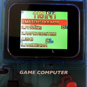 May include: A handheld game console with a screen displaying a list of games. The screen shows the text "118 IN 1" at the top, followed by game titles like "MATCH STICK MAN" and "RACING CAR". The console is blue and has the words "GAME COMPUTER" printed on it.