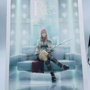 May include: A promotional image for Final Fantasy, featuring a character with pink hair seated on a light blue sofa, holding a sword. The image has the word "Re:" at the top, with text below it. The overall aesthetic is futuristic.