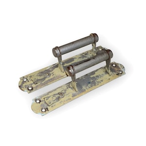 May include: A pair of antique door handles with a distressed, light green finish. The handles are made of metal and have a cylindrical shape. Each handle is attached to a rectangular plate with decorative edges.