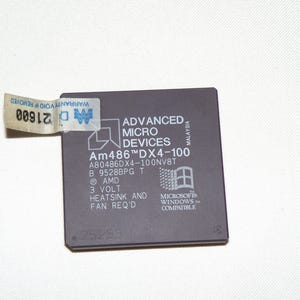 May include: A dark gray Advanced Micro Devices Am486DX4-100 processor with text and a Microsoft Windows logo. A sticker with the text "Warranty Void if Removed" is attached. The processor is a square shape.