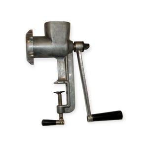 May include: A vintage, silver-colored meat grinder with a hand crank and a clamp for securing it to a surface. The grinder has a cylindrical body, a feeding chamber, and a grinding plate. The handle and clamp knobs are black.