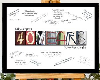 May include: A black framed print with a white background featuring a colorful collage of letters spelling out "40 YEARS" with the date "November 5, 1982" below. The print is on an easel and has handwritten messages on the white background.
