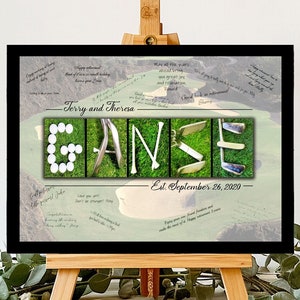 May include: A black framed golf-themed wedding guest book with the couple's last name "GANSE" spelled out using golf equipment and golf balls. The date "Est. September 26, 2020" is written below the name.