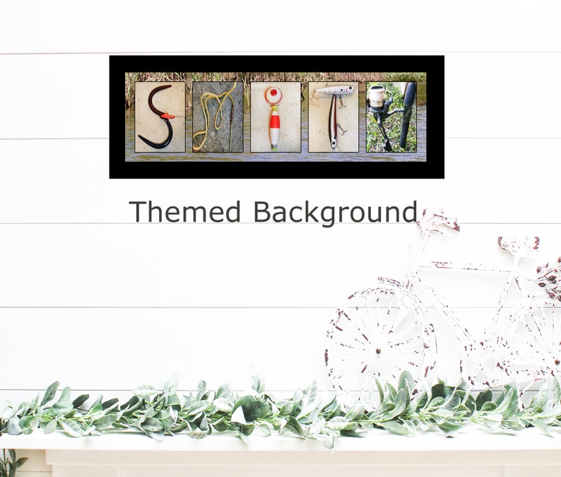 May include: A framed print with the word "SMIT" spelled out using fishing-themed images. The background is a light blue woodgrain pattern. The print is framed in black with a white mat.